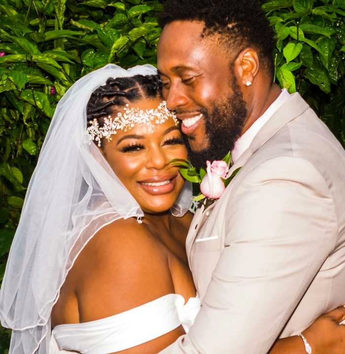 Couple in white attire embracing close