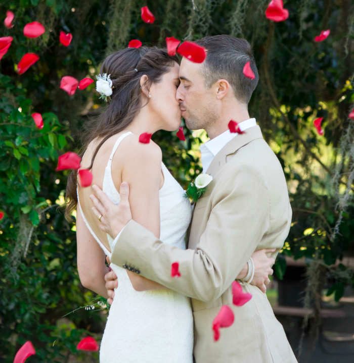 Couple kissing in rose petal shower